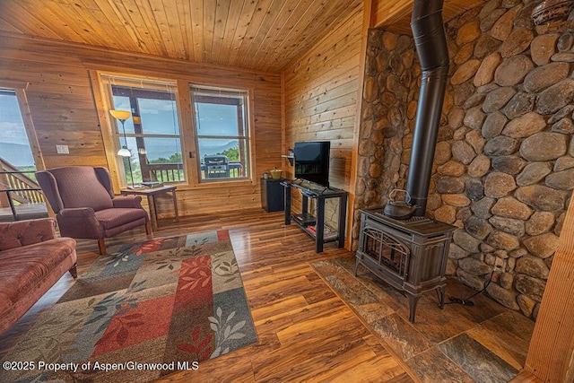1349 Eagle Loop, Craig, CO 81625 - living area featuring a wood stove, plenty of natural light, wood walls, wood-type flooring, and wood ceiling