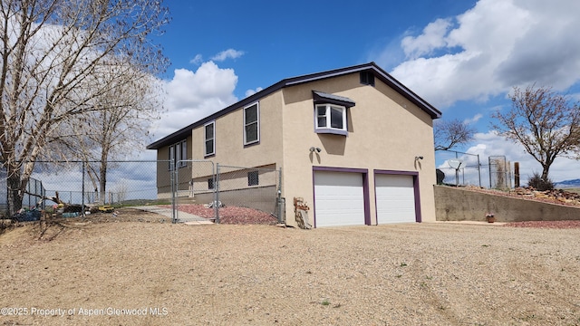 3294 County Road 103, Craig, CO 81625 - view of home's exterior featuring fence, a gate, stucco siding, and an attached garage