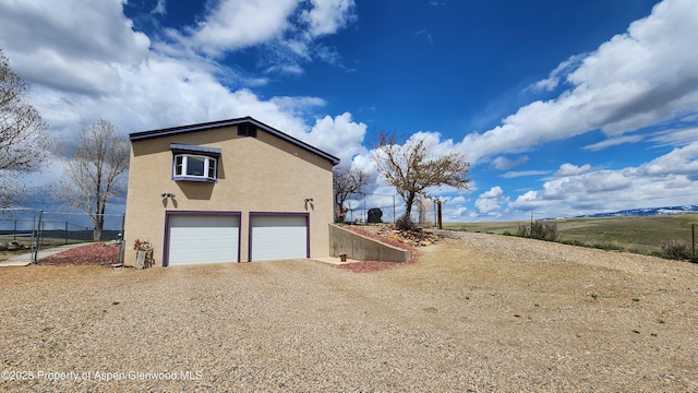 3294 County Road 103, Craig, CO 81625 - view of home's exterior with a garage, stucco siding, driveway, and fence