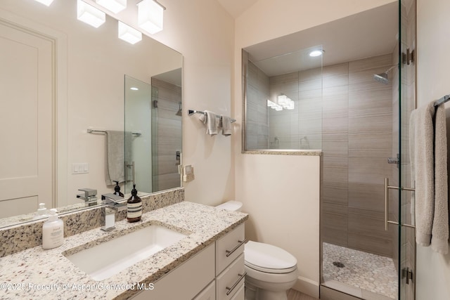 full bath featuring vanity, toilet, and a tile shower