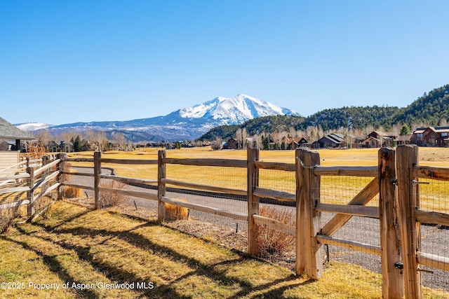 view of yard featuring a rural view, a mountain view, and fence