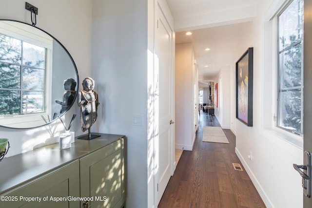 hallway featuring visible vents, recessed lighting, dark wood-type flooring, and baseboards