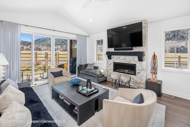 living room featuring visible vents, a healthy amount of sunlight, wood finished floors, and vaulted ceiling