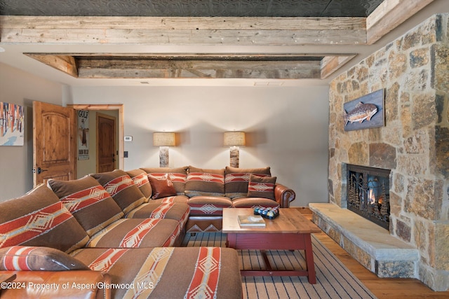 living room with hardwood / wood-style floors and a stone fireplace