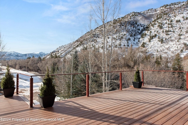 snow covered deck featuring a mountain view