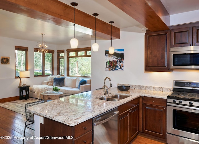 kitchen featuring sink, light stone countertops, beamed ceiling, and appliances with stainless steel finishes