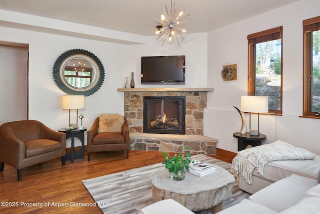 living room featuring an inviting chandelier, hardwood / wood-style flooring, and a fireplace