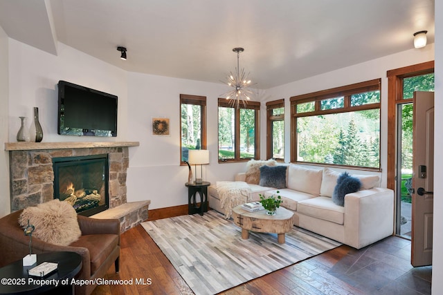 living room with an inviting chandelier, a fireplace, and dark hardwood / wood-style floors