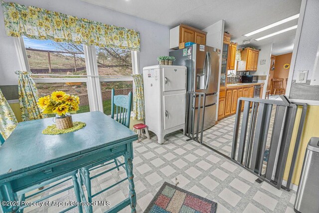 1097 Kowach Dr, Craig, CO 81625 - kitchen featuring light floors, stainless steel refrigerator with ice dispenser, brown cabinetry, a sink, and light countertops