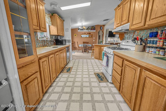 1097 Kowach Dr, Craig, CO 81625 - kitchen featuring white range with gas cooktop, light countertops, light floors, under cabinet range hood, and stainless steel dishwasher