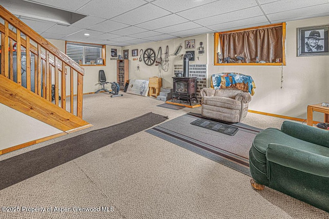 1097 Kowach Dr, Craig, CO 81625 - carpeted living area featuring a wood stove, baseboards, a drop ceiling, and stairs