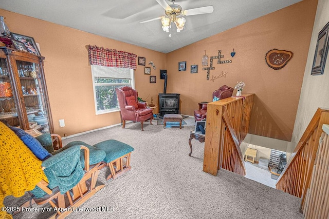 1097 Kowach Dr, Craig, CO 81625 - sitting room with a ceiling fan, a wood stove, carpet floors, vaulted ceiling, and baseboards