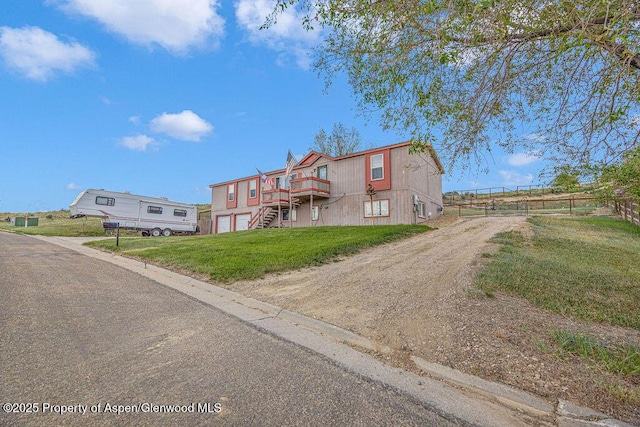 1097 Kowach Dr, Craig, CO 81625 - view of front facade with driveway, a deck, a garage, and stairs