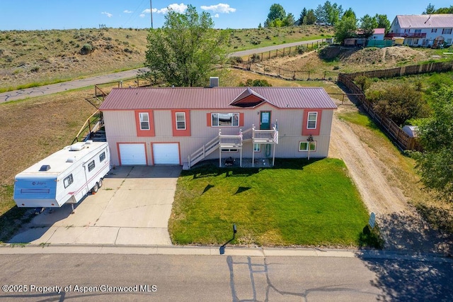 1097 Kowach Dr, Craig, CO 81625 - view of front facade featuring concrete driveway, an attached garage, stairs, a metal roof, and a front yard