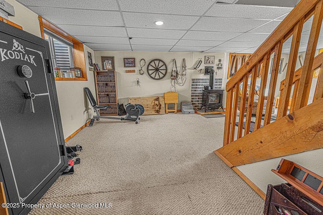 1097 Kowach Dr, Craig, CO 81625 - workout area with carpet flooring, a wood stove, baseboards, and a drop ceiling