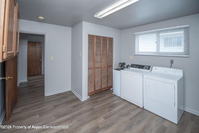 750 Breeze St, Craig, CO 81625 - washroom featuring washer and clothes dryer, light wood-style floors, and cabinet space