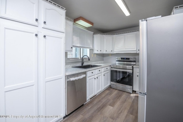 750 Breeze St, Craig, CO 81625 - kitchen with stainless steel appliances, white cabinetry, wood finished floors, and light countertops