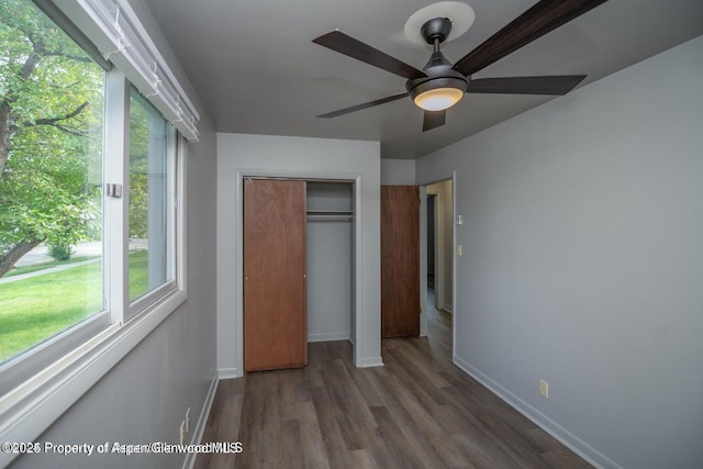 750 Breeze St, Craig, CO 81625 - unfurnished bedroom featuring wood finished floors, a closet, multiple windows, and ceiling fan