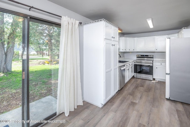 750 Breeze St, Craig, CO 81625 - kitchen featuring stainless steel appliances, white cabinetry, wood finished floors, and light countertops