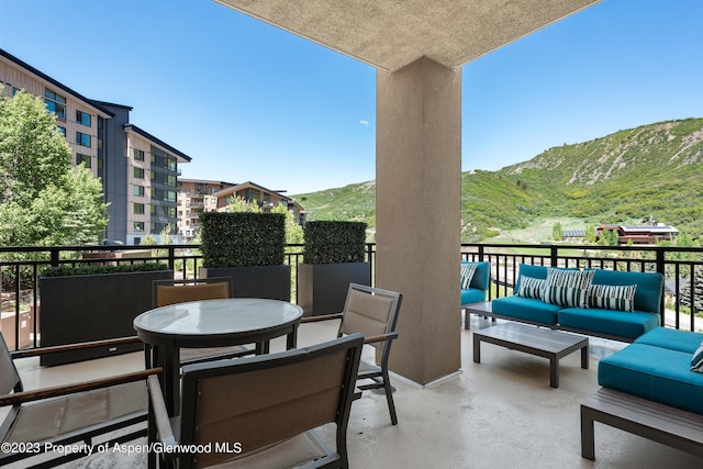 view of patio with an outdoor living space, a balcony, and a mountain view