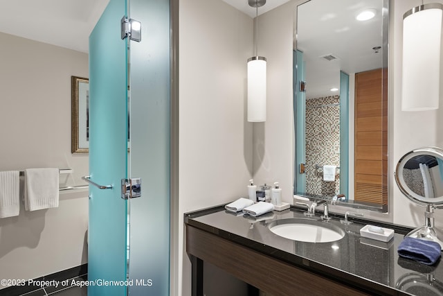 bathroom featuring a shower and vanity