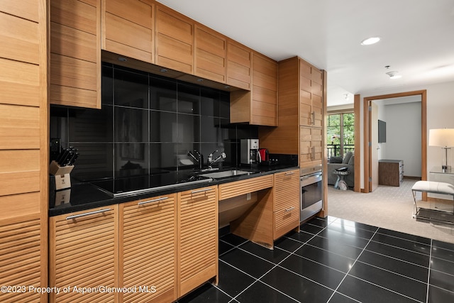 kitchen with dark colored carpet, oven, and sink