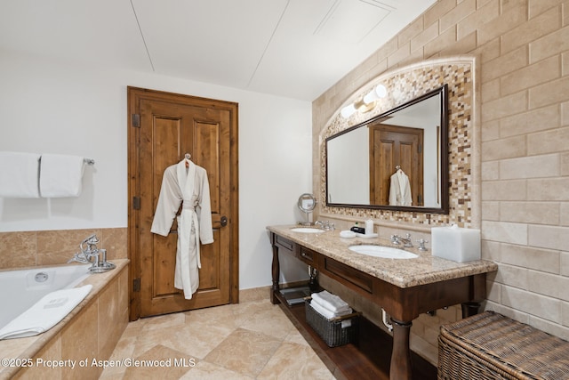 bathroom with a garden tub, double vanity, and a sink