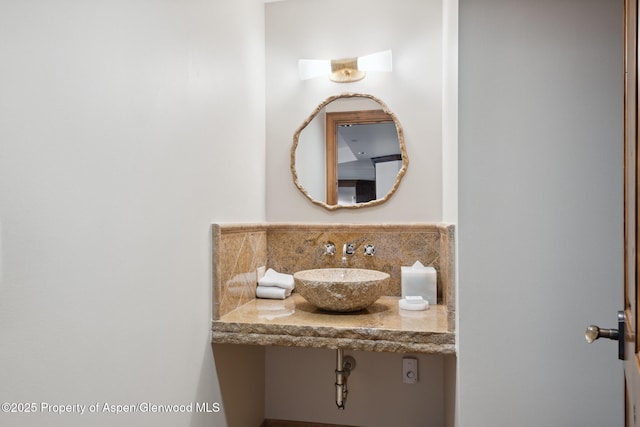 bathroom with a sink and decorative backsplash