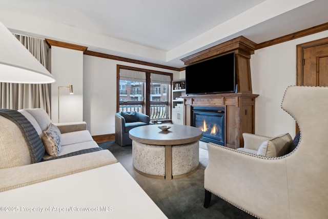 living area featuring a glass covered fireplace and baseboards