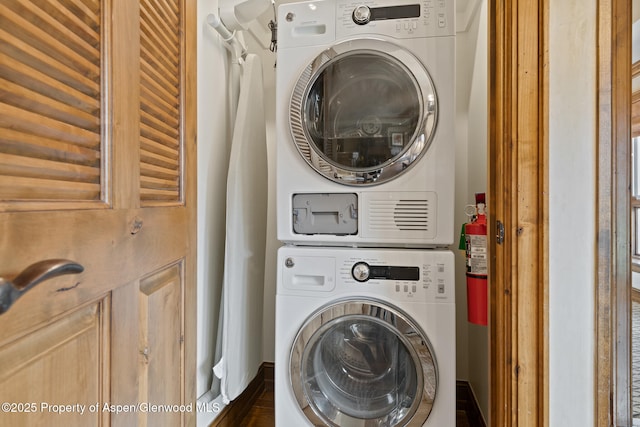 washroom with stacked washing maching and dryer