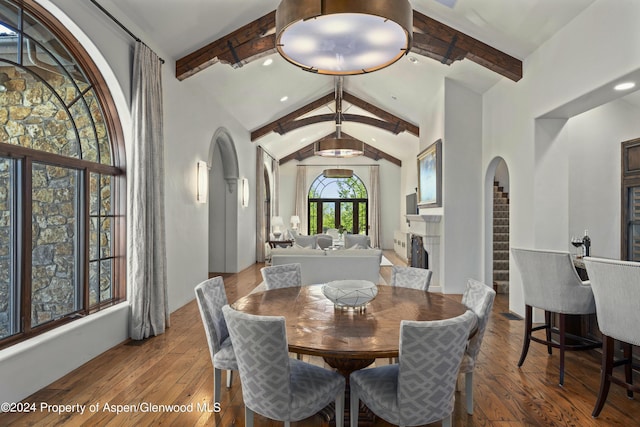 dining space featuring vaulted ceiling with beams and hardwood / wood-style floors