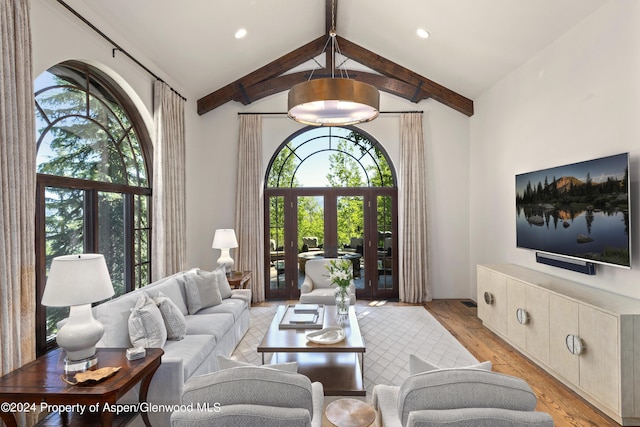 living room featuring vaulted ceiling with beams, french doors, and light hardwood / wood-style flooring