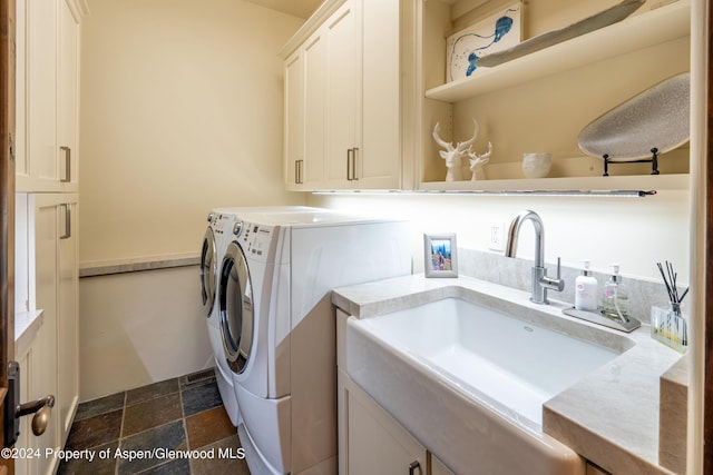 laundry room featuring washer and dryer, cabinets, and sink