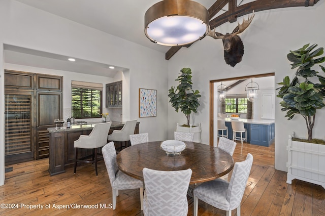 dining area with a wealth of natural light, hardwood / wood-style floors, and lofted ceiling with beams