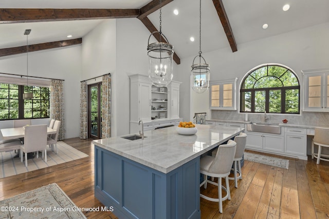 kitchen featuring decorative light fixtures, white cabinetry, and sink