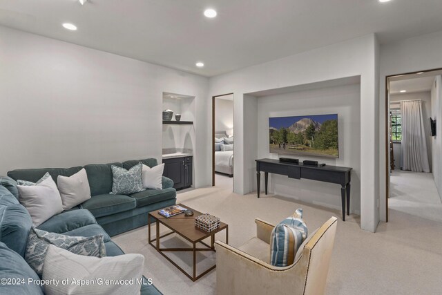 living room featuring light carpet and built in shelves