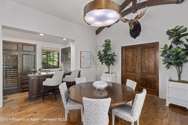 dining room featuring lofted ceiling with beams and dark wood-type flooring