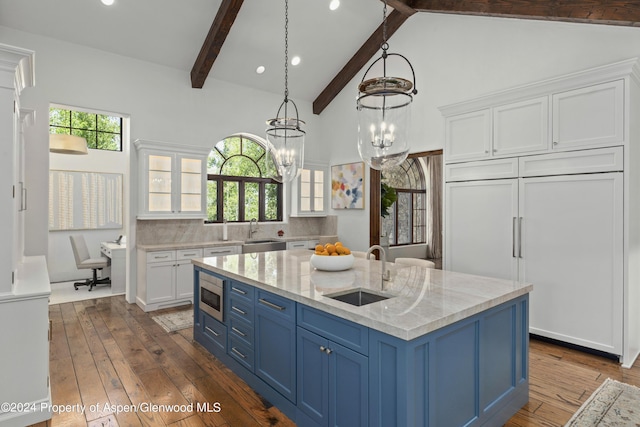 kitchen featuring built in appliances, white cabinetry, sink, and blue cabinets