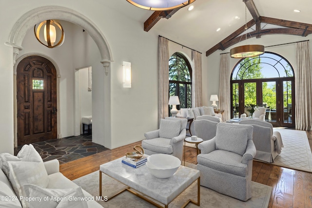 living room with dark hardwood / wood-style floors, beam ceiling, high vaulted ceiling, and french doors