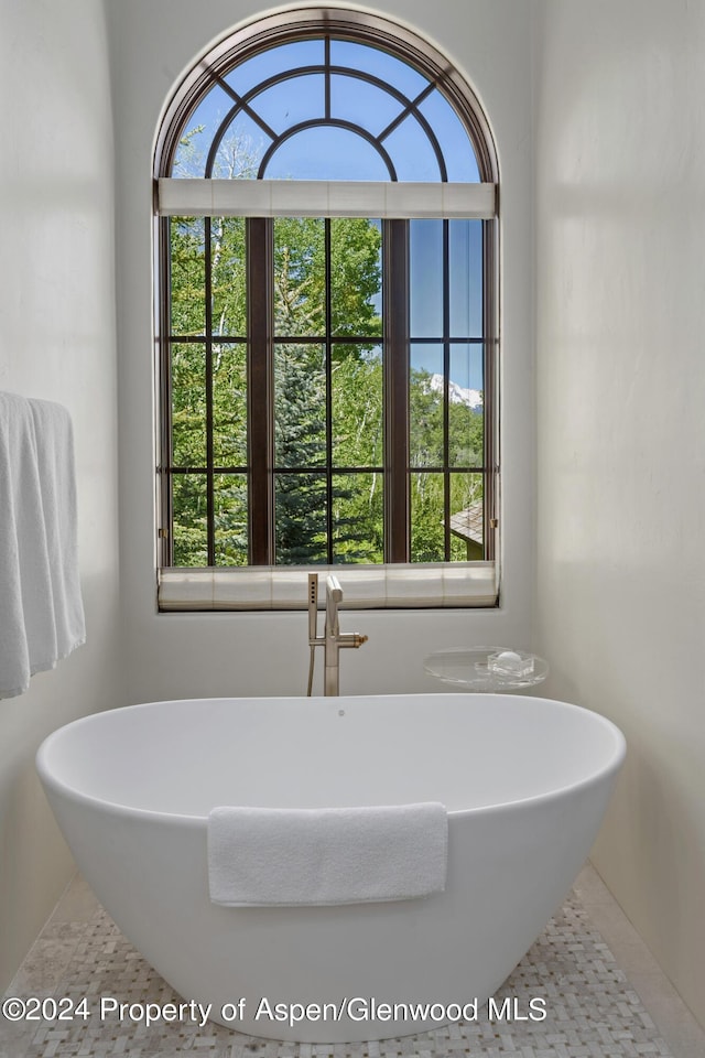 bathroom with tile patterned floors and a tub