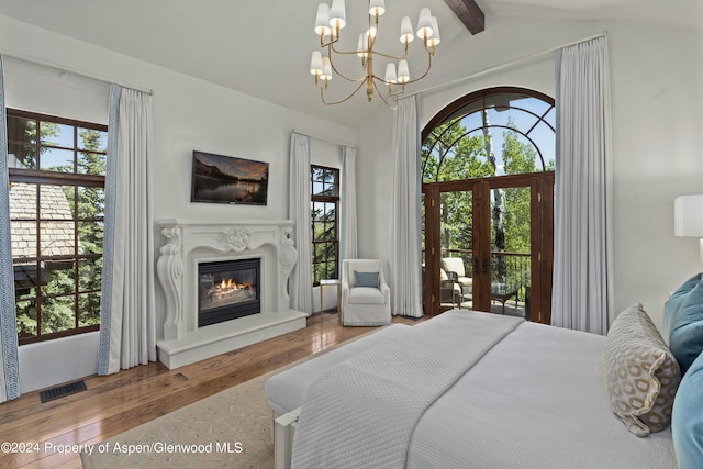 bedroom featuring a chandelier, vaulted ceiling with beams, hardwood / wood-style flooring, and multiple windows