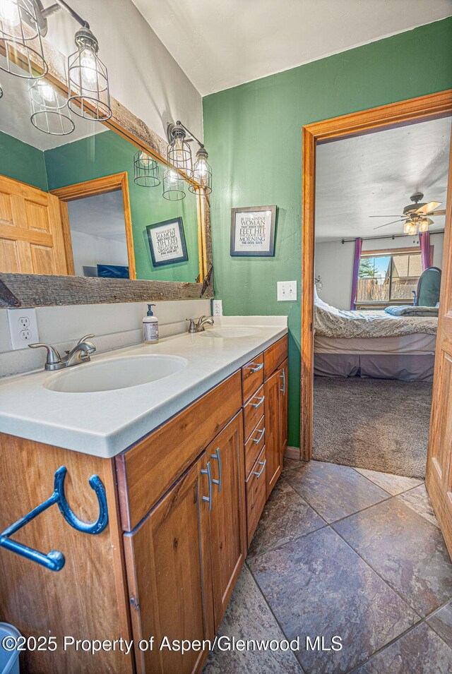 352 Lake View Rd, Hayden, CO 81639 - ensuite bathroom with double vanity, stone finish floors, and a ceiling fan