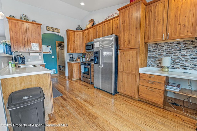 352 Lake View Rd, Hayden, CO 81639 - kitchen with stainless steel appliances, a sink, decorative backsplash, light wood-style floors, and light countertops