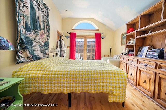 bedroom featuring light wood-style floors and lofted ceiling