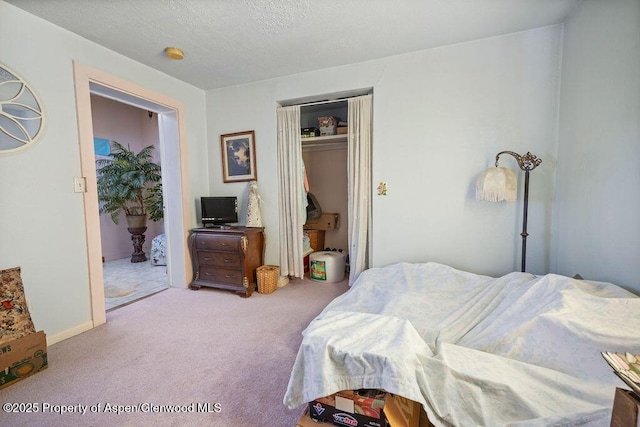 carpeted bedroom with a closet and a textured ceiling