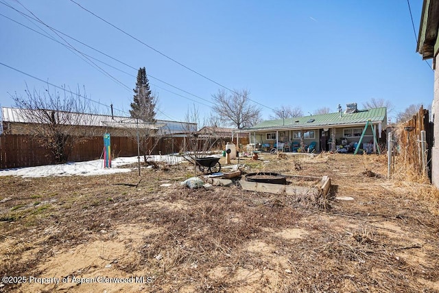 view of yard featuring a fenced backyard and a fire pit