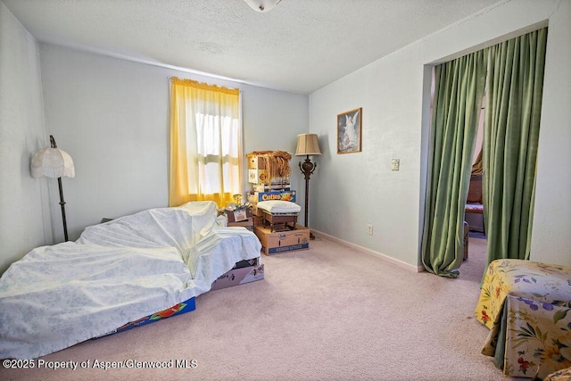 bedroom featuring a textured ceiling, carpet flooring, and baseboards