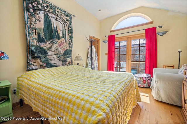 bedroom featuring vaulted ceiling, wood finished floors, and french doors