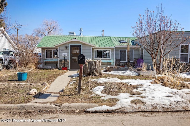 view of front of home with stone siding and metal roof