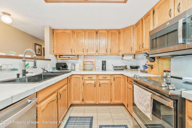 565 Sandrock Dr, Craig, CO 81625 - kitchen with appliances with stainless steel finishes, a sink, light tile patterned floors, and tile countertops